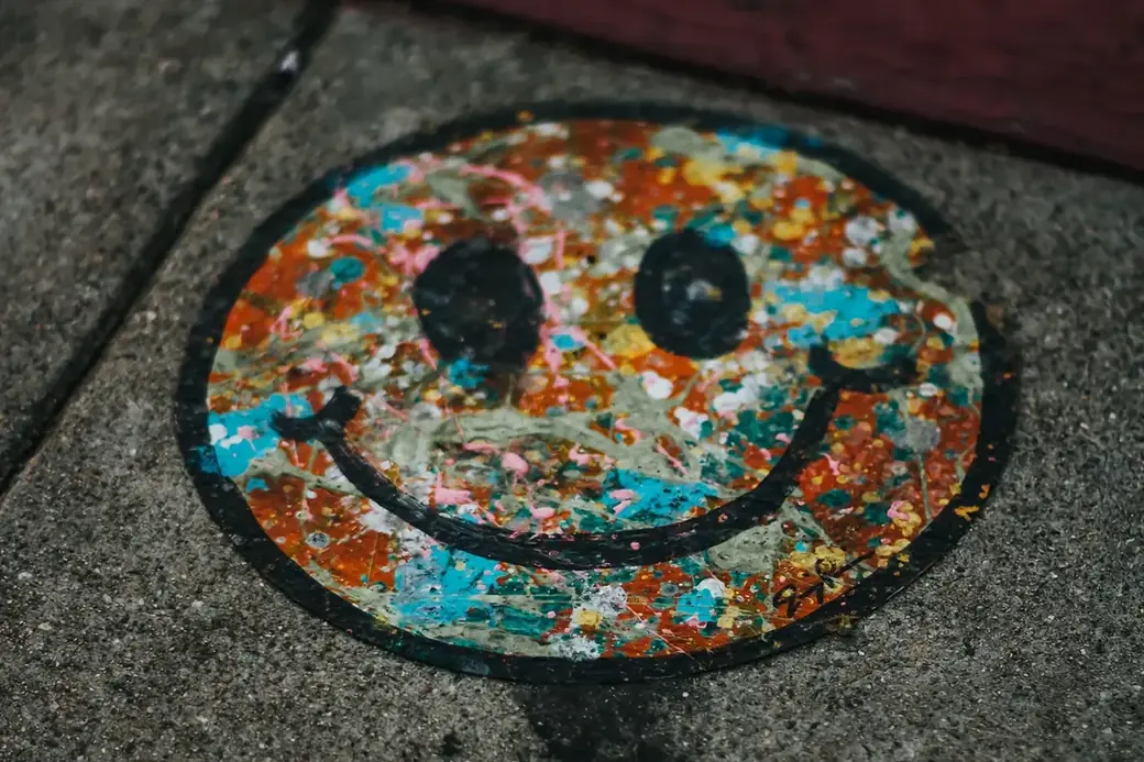 Bunt bemaltes Smiley-Gesicht auf einer Gehwegplatte